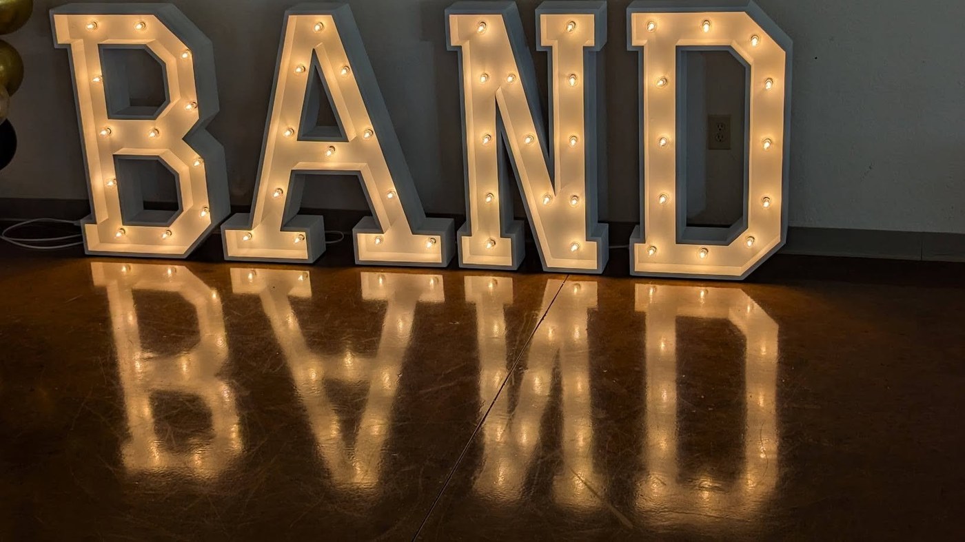 Illuminated marquee letters spelling BAND on their own as a standalone display