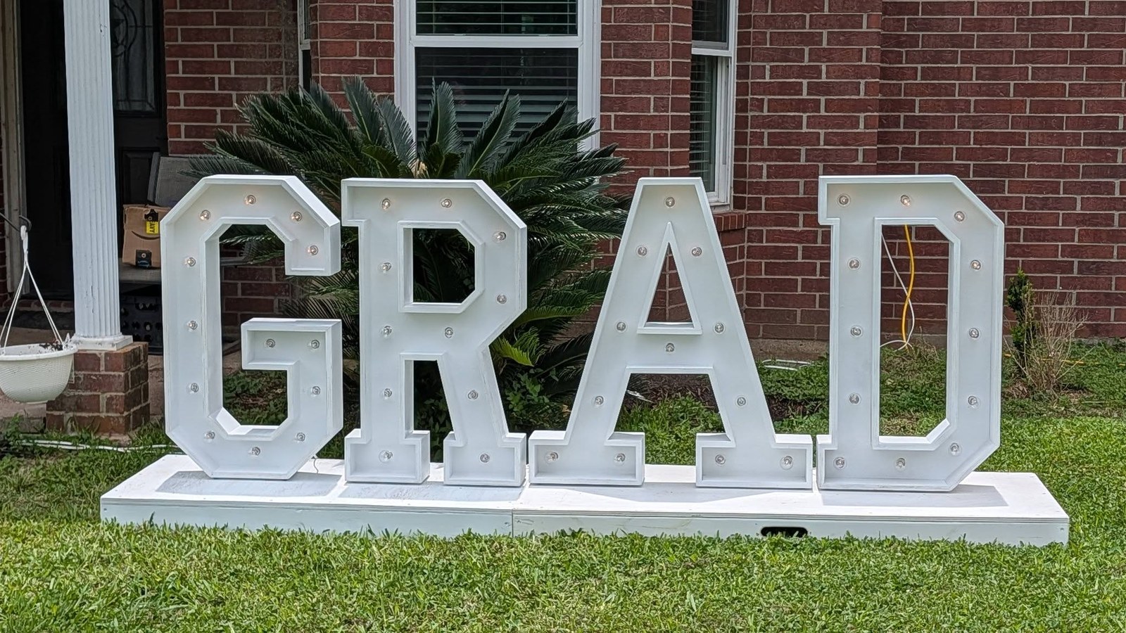 Illuminated marquee numbers 2026 set up in a front yard for a graduation party